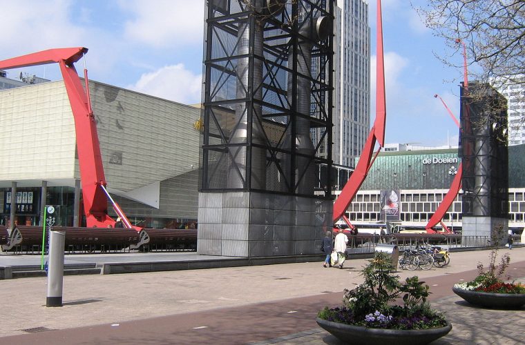 Openluchtbioscoop op het Schouwburgplein in Rotterdam met films op groot scherm onder de sterrenhemel, omringd door karakteristieke architectuur.